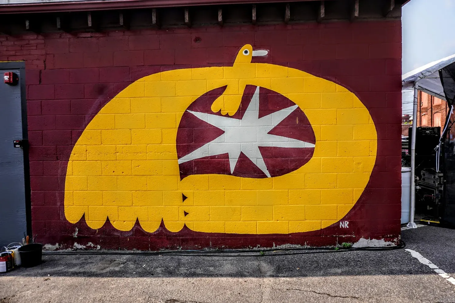 The yellow bird mural on the side of the building at 48 Emerald Street